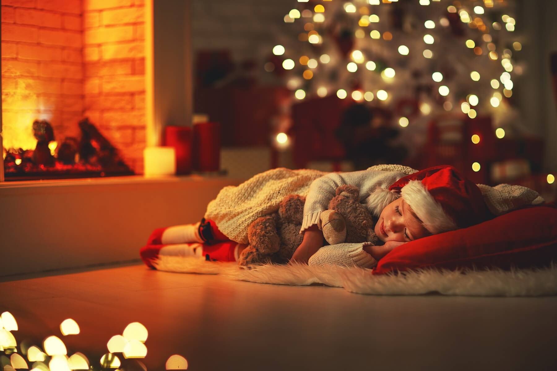 child girl fell asleep near tree on Christmas Eve